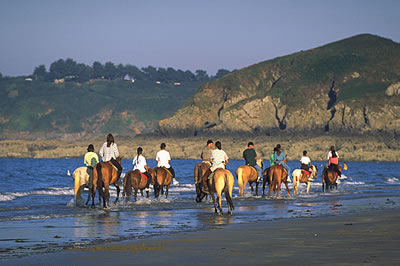 Reiten in der Bretagne. An der Küste und Stränden der Bretagne kann man ausgezeichnet reiten. Ein schöner Ausflug im Urlaub für die Familie.