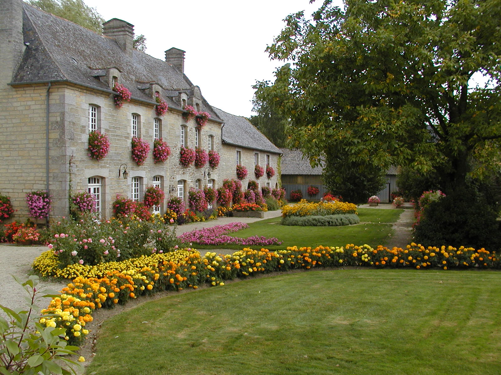 Ein schöner Bauernhof in St. Juvat, Cotes-d'Armor im Nordwesten von Frankreich mit einer prachtvollen Parkanlage vor dem Hof.