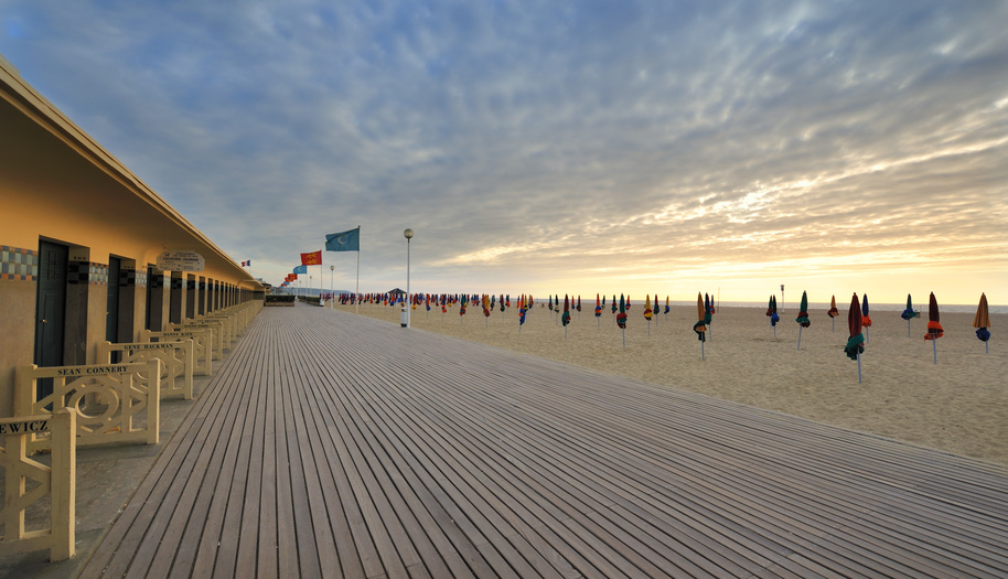 Der Strand von Deauville am Abend mit einem romantischen Sonnenuntergang. Der Luxusurlaubsort in Deauville bietet einen Kilometerlanger Sandstrand.