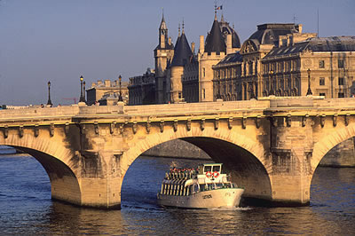 Blick vom Quai du Louvre auf den Pont Neuf, die älteste noch erhaltene Brücke über die Seine in Paris. Unter der Brücke eine Bootstour.