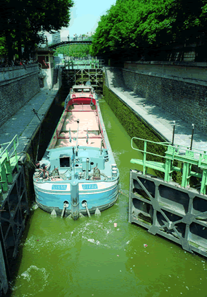 Canal Saint-Martin ist ein Schifffahrtskanal im Osten von Paris. Gut zu sehen ist ein Schiff, dass gerade in der Schleuse ist.