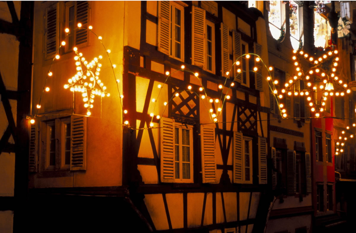 Eine schöne mit Lichtern und Weihnachtsschmuck behangene Straße in Colmar zur Weihnachtszeit in Frankreich