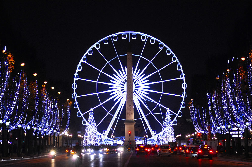 Das Riesenrad und der Obelisk auf der Place de la Concorde mit Blick von der
beleuchten Champs-Elysees zu Weihnachten.