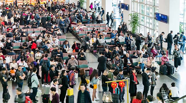 Überfüllte Flughalle mit wartenden Passagieren