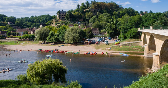 Limeuil, Frankreich: Familien von Touristen, die Wassersport auf der Dordogne genießen, im Kanu paddeln und im Wildwasser schwimmen; das Dorf zählt zu den „Schönsten Dörfern Frankreichs“