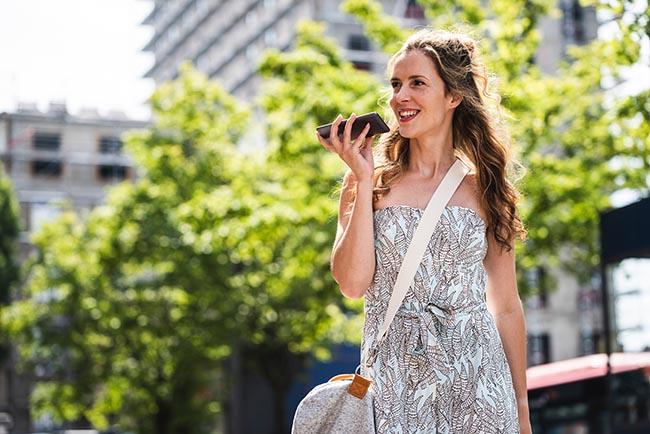 Frau telefoniert in Frankreich über ihr Smartphone nach Hause